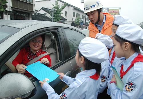 9月22日,苏州市“小交警”向车主发放“绿色出行”倡议书。当天是“无车日”,全国各地群众积极行动,倡导步行、骑自行车、乘公交车等方式绿色出行。新华社发(朱桂根 摄)