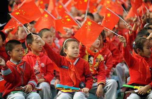 10月13日,少先队员在沈阳市举行的纪念中国少年先锋队建队60周年活动上舞动国旗。新华社发(杨新跃 摄)
