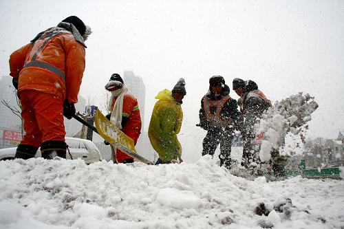 1月3日,环卫工人在天津街头清除积雪。从1月2日夜间开始的大雪给天津道路交通造成一定影响,相关部门启动除雪应急预案,全市万余名环卫工人走上街头清扫积雪,保障市民安全出行。新华社发(刘嘉琪 摄)