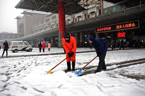 1月3日早晨,北京西客站的工作人员在清理积雪。当日,北京普降大雪。新华社发(傅纯荣 摄)