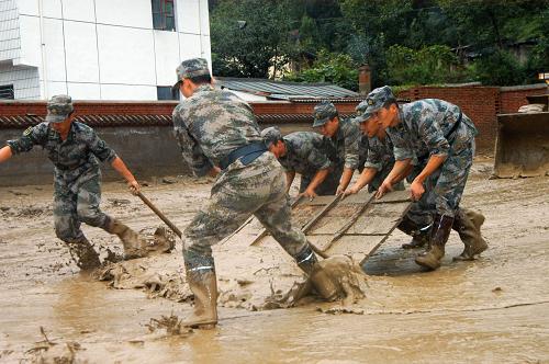 第二炮兵某部官兵在重灾区黄渚镇小太阳幼儿园清理淤泥(8月20日摄)。新华社记者 吴明轩 摄