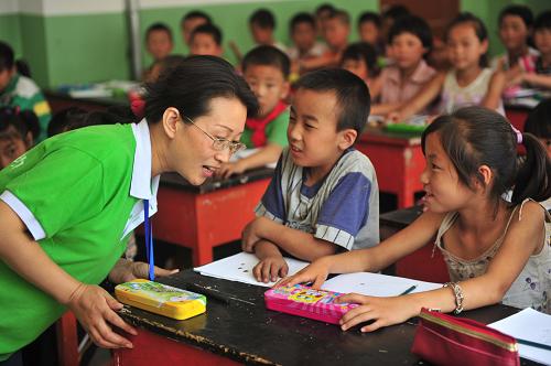 8月26日,在舟曲县第一小学4年级2班,专业从事心理干预的心理咨询师郝思明和小学生们交流互动。为帮助灾区学生走出灾害阴影,重新建立健康乐观的心态,甘肃省卫生厅组织的心理卫生专家和社会心理援助志愿者一起在舟曲中小学校开展心理干预辅导课程。同时甘肃省还派出一支10人组成的健康教育队,给学生宣讲灾害后日常生活健康卫生知识,教育孩子们养成良好的健康生活习惯。新华社记者 梁强 摄