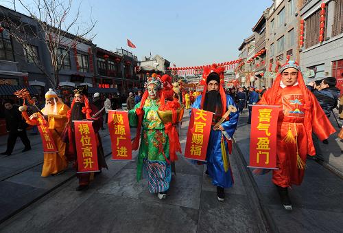1月26日,北京前门大街天街年市上,演员在表演“五福送财”向过往游人拜早年。新华社发
