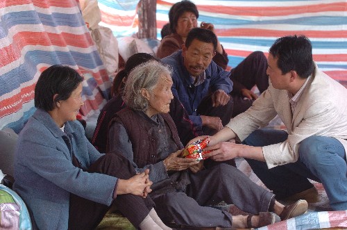 2008年5月14日,甘肃徽县的乡镇干部在给受灾群众发放生活用品。 新华社记者王志恒摄
