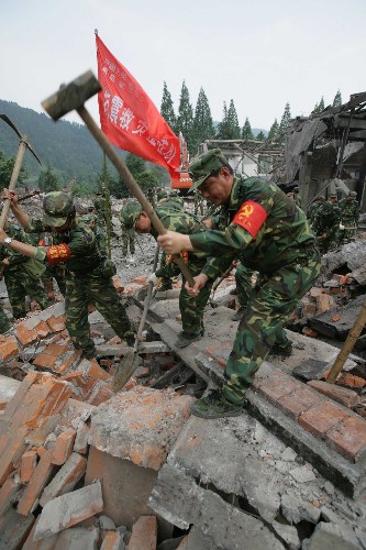 2008年6月9日,成空航空兵某师副师长侯卿明带领“党员突击队”在四川彭州银厂沟灾区清理废墟。 新华社发(刘应华摄)