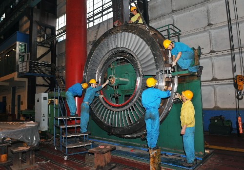 4月17日,东方汽轮机厂的工人们在燃汽轮机的透平叶环旁工作。 位于四川省德阳市汉旺镇的东方汽轮机厂,是国家研究、设计、制造大型电站汽轮机的大型骨干企业,是世界上制造能力最强的汽轮机制造企业之一。2008年5月12日,突如其来的特大地震,瞬间摧毁了东汽大片厂房和大量设备,几百人遇难,上千人受伤。然而,东汽人没有被地震震垮,他们以特有的坚忍和毅力,从余震不断的废墟上跃起。他们掩埋好遇难同伴和亲人的遗体,擦干泪水,抗震救灾,恢复生产。目前,东方汽轮机厂已全面完成了2008年灾后制定的各项生产经营任务,完成产品产量2320万千瓦、实现工业总产值108亿元、销售收入89亿元,新增订货239亿元,以辉煌的业绩书写了中国工人阶级“泰山压顶不弯腰”的伟大篇章。 新华社记者 何俊昌 摄