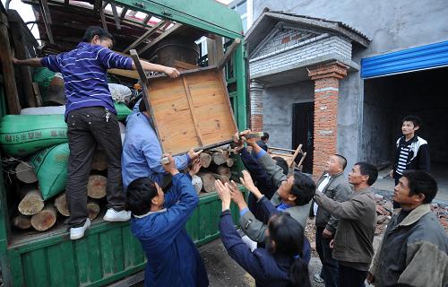 搬到荆门市叶坡安置点的移民们在互相帮忙卸载家具(10月20日摄)。 10月20日,丹江口市习家店镇的第四批94户库区移民一起搬迁到湖北省荆门市的屈家岭管理区。走出大山,来到新移民安置点的南水北调库区移民开始了新的生活,逐步走向安居乐业。 搬进新居的第一天,移民们开始布置新家,并在新家里吃上了第一顿饭。条件还有些简陋,家里还有些凌乱,移民们还显得有些忙碌和陌生。但是新的一切毕竟拉开了帷幕。生活方式改变了——原先靠养鱼和种植柑桔致富的他们,搬进了楼房,用上了自来水,并在已经分得的菜地里开始习惯着耕种生活。对于库区移民们来说,新的生活才刚刚开始。 新华社记者李晓果摄