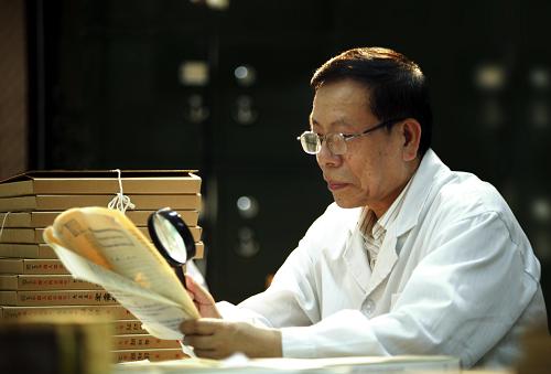 20多年来,解放军优秀档案专家刘义权为国家征集和接收了83万多件珍贵的军事档案。借助这些档案,解放军档案馆帮助有关单位和个人,查找了近万名我军失踪和牺牲人员下落线索。就在确诊为直肠癌晚期后,他还坚守在中美军事档案合作一线,鉴定了5万多件志愿军历史档案。2009年10月11日,刘义权同志先进事迹报告会在北京人民大会堂举行。 这是刘义权在鉴定档案(2009年7月9日摄)。 新华社发 (王安民 摄)