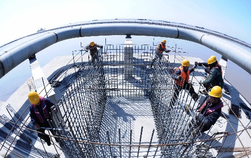 3月26日,施工人员为全长13.5公里的码头输油管进行配套设施建设。 总投资额13.79亿元的天津港30万吨级原油码头工程正在加紧建设中,目前已累计完成建设投资7.4亿元,码头13.5公里长的输油管线已全部安放就位,计划2008年9月初投入试运营。据介绍,天津港30万吨级原油码头泊位总长468米,可停靠10万吨级至30万吨级大型原油船舶,年设计吞吐能力2000万吨,不仅为中石化天津100万吨乙烯项目提供配套服务,还将为华北四大炼油企业提供服务。 新华社记者刘海峰摄