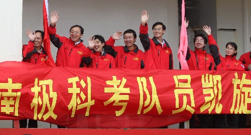 4月15日,科考队员在即将靠岸的“雪龙”号上向欢迎的人群挥手致意。 新华社记者 裴鑫 摄
