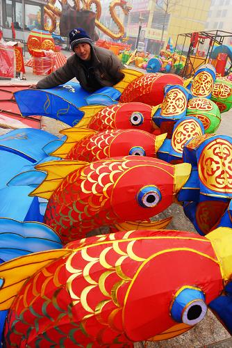 2月22日,一名工人在山东邹平县花灯街安装“年年有余”花灯。 近日,山东邹平县元宵艺术节花灯街的安装工作接近尾声,花灯街集中了50余组大型花灯,将在元宵节期间精彩亮相。新华社发