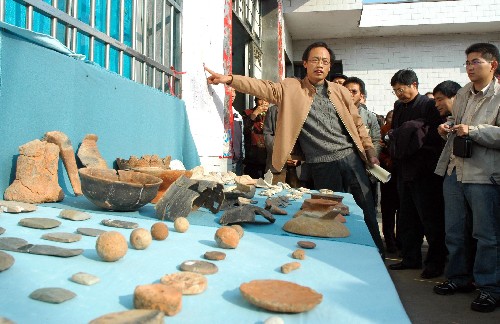 12月6日,考古人员在汤家岗遗址附近向专家、记者介绍情况。