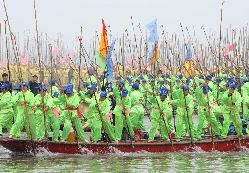 4月6日,村民们手持长篙在会船中奋力争先。