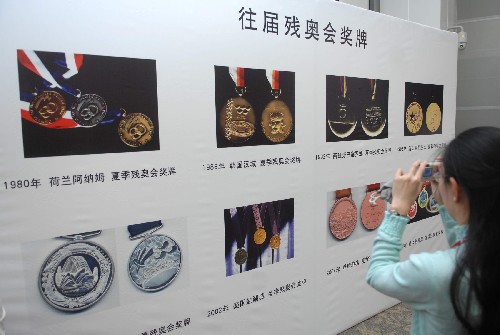 11月14日,一名记者在北京奥运新闻中心拍摄历届残奥会奖牌图样。当日,北京奥组委在北京奥运新闻中心发布了北京2008年残奥会奖牌式样。 新华社记者 罗晓光 摄
