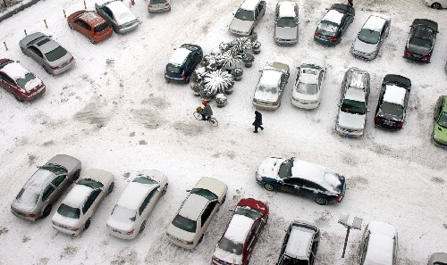 两位武汉市民从雪地上走过(1月27日摄)。 新华社记者 余国庆 摄