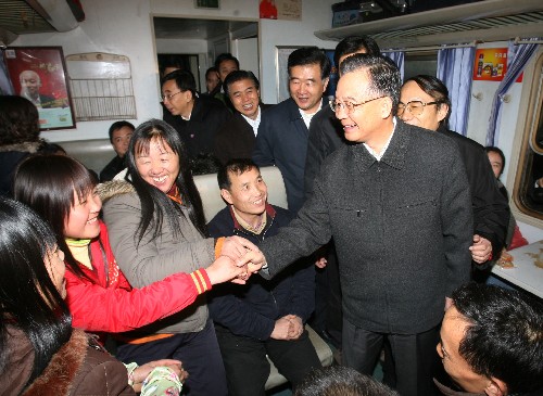 1月30日,中共中央政治局常委、国务院总理温家宝在广州火车站看望旅客。这是温家宝总理登上一列即将发往南昌的火车与旅客交谈。 新华社记者 姚大伟 摄