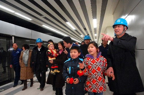 2月4日,在北京地铁10号线双井站,中国铁建16局的部分施工人员陪同家属参观即将试运行的地铁10号线,让亲人感受自己的建设成果。这些来自湖南、重庆、四川等地的北京地铁建设者因南方雪灾未能返乡,有关部门组织丰富多彩的活动,让留京的建设者度过一个欢乐祥和的新春佳节。 新华社发