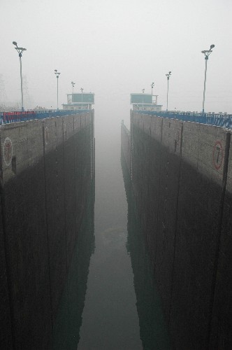 3月16日拍摄的浓雾笼罩的葛洲坝船闸。 受浓雾天气影响,三峡双线五级船闸自15日22时40分起停航。与此同时,相距38公里的葛洲坝一、二、三号船闸也因浓雾全部关闭停航。截至3月16日16时,两坝船闸仍处于关闭中。 新华社发(刘保平 摄)
