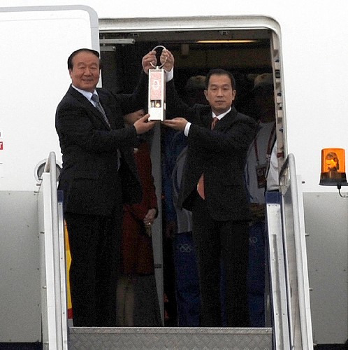 4月23日,北京奥组委执行副主席蒋效愚(左)和中国驻澳大利亚大使章均赛手持火种灯走出机舱。当日,北京奥运圣火抵达澳大利亚首都堪培拉。 新华社记者 黄本强 摄