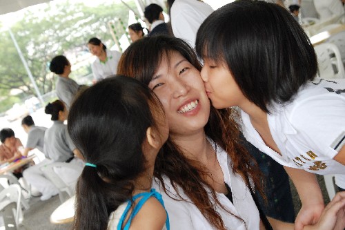 2008年5月11日 ,在马来西亚吉隆坡,两姐妹轻吻妈妈的脸。当天,马来西亚各地举办多场活动庆祝母亲节。 新华社发(张纹综摄)