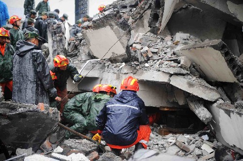 5月13日,救援人员继续在四川都江堰市聚源镇聚源中学冒雨进行救援工作,虽然地震造成大量伤亡,但仍有迹象表明废墟中有幸存者。 新华社记者 王建华 摄