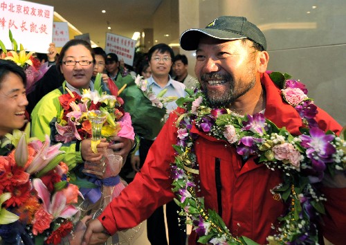 5月15日,珠峰火炬传递第二棒火炬手、中国登山队队长王勇峰(右)等在首都国际机场受到热烈欢迎。当日,北京时间凌晨4时20分,参加北京奥运会火炬接力珠峰传递的部分中国登山队队员和工作人员抵达北京首都国际机场3号航站楼。 新华社记者 罗晓光 摄