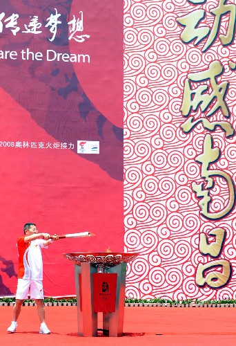 5月16日,奥运火炬手简勤在城市庆典上点燃圣火盆。当日,北京奥运圣火传递活动在江西南昌举行。 新华社记者 刘力航 摄