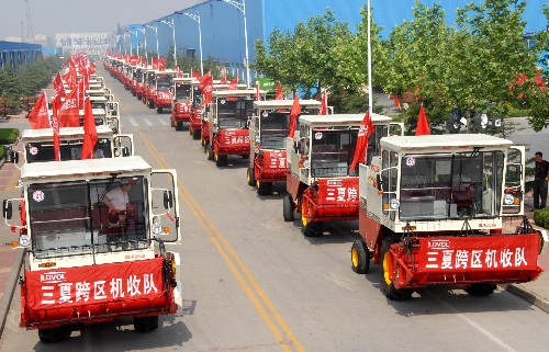 5月22日,参加“三夏”跨区服务的农机准备出发。 当日,山东潍坊参加2008年“三夏”跨区作业的农机手和某农业装备制造企业的服务人员一起出发,奔赴山西、河南等省市的麦收一线,展开为期一个半月的“三夏”麦收大会战。 新华社发(曹亮华 摄)