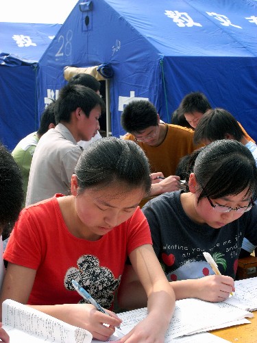 5月23日,宁强县第一中学高三学生在临时“教室”外复习。 四川汶川大地震发生后,与四川震区毗邻的陕西省宁强县26个乡镇全部受灾,全县233所中小学有226所受灾。陕西省有关部门正全力帮助当地受灾学校搭建临时校舍、加快校舍维修等,力争让学生们早日复课。 新华社发(郑元平 摄)