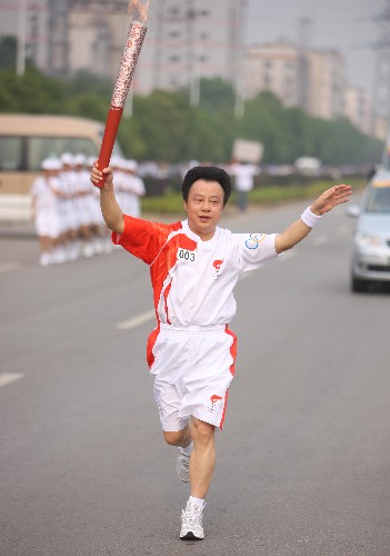 6月5日,火炬手余爱国手持火炬传递。当日,北京奥运圣火在湖南湘潭传递。 新华社记者 邢广利 摄