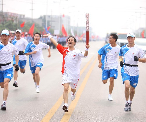 6月5日,火炬手汤国强手持火炬传递。当日,北京奥运圣火在湖南湘潭传递。 新华社记者 邢广利 摄