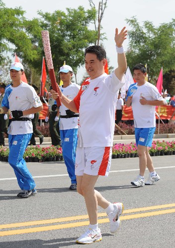 6月30日,火炬手夏林手持火炬传递。当日,北京奥运圣火在宁夏吴忠传递。 新华社记者 安治平 摄