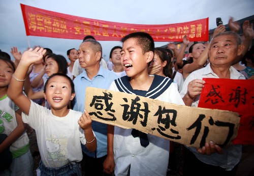 7月23日,一名灾区的孩子在欢送的人群中失声哭泣。 新华社记者 查春明 摄