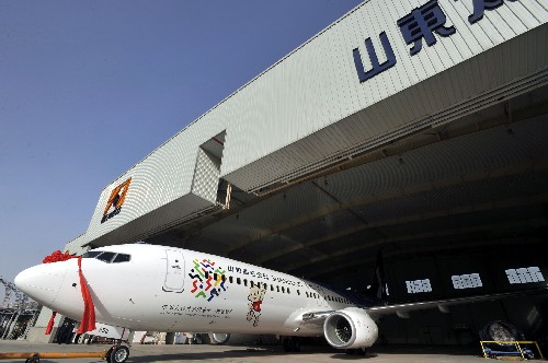 3月13日,“全运号”飞机驶出机库。 当日,由山东航空公司为第十一届全国运动会定制的“全运号”飞机在山东济南亮相。“全运号”飞机机型为波音737-800,是一架168座的中型客机。机身前部绘有第十一届全运会会徽和本届全运会吉祥物“泰山童子”形象,机身后部喷涂“2009山东”字样。“全运号”飞机将主飞北京、上海、广州、南京等曾经举办过全运会的城市航线,除执行正常航班之外,还将按照全运会组委会要求,配合全运会的宣传活动,执行指定航线任务,加大对全运会的推介力度。 新华社记者 朱峥 摄