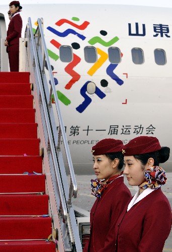 3月13日,“全运号”飞机空乘人员站在飞机舷梯旁。 新华社记者 朱峥 摄