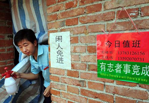 6月6日,河南省嵩县何村乡的“大学生村官”王铁伟在完成了消毒工作后走出食用菌生产车间。 新华社记者 王颂 摄