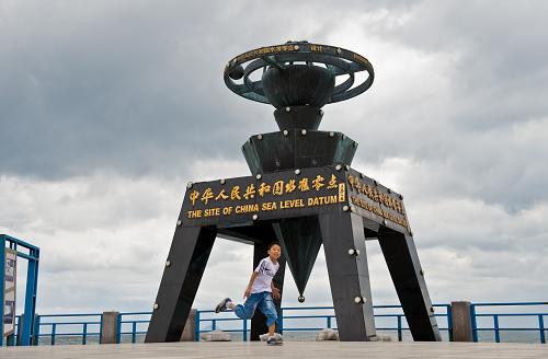 8月11日,一位小朋友在“中华人民共和国水准零点”标志景区里玩耍。新华社记者杨光摄