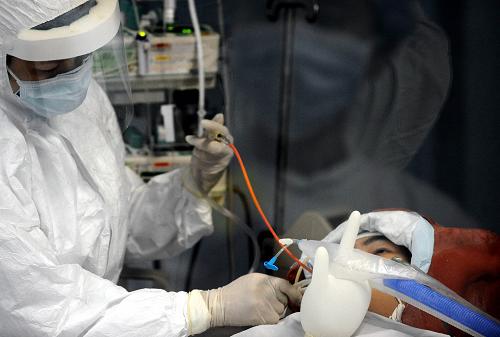 8月13日,医护人员在广州呼吸疾病研究所ICU负压病房里护理甲型H1N1流感重症病例患者。新华社记者 陈晔华 摄