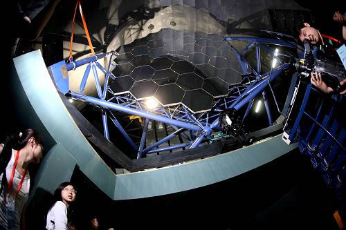2009年6月4日,目前国际上口径最大的大视场望远镜、国家重大科学工程——大天区面积多目标光纤光谱天文望远镜(LAMOST)项目在中国科学院国家天文台兴隆观测基地通过国家竣工验收。这是参观者在观看天文望远镜部分设备。LAMOST突破了国际上半个世纪以来天文望远镜大口径和大视场难以兼备的瓶颈,是一架我国自主创新设计、在技术上极具挑战性的大视场兼备大口径光学天文望远镜,也是世界上光谱获取率最高的望远镜。新华社记者汪永基摄