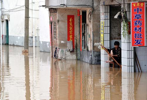 6月17日,一位居民在家门口查看水情。当日,广西桂林市出现大到暴雨、局部大暴雨天气,部分城区不同程度出现内涝,部分乡镇农田和房屋被淹。新华社记者 陈瑞华 摄
