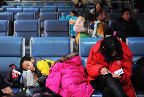 1月30日凌晨,旅客在哈尔滨火车站候车室休息等待。 当日,2010年全国铁路春运拉开帷幕。为期40天的铁路春运预计将发送旅客2.1亿人次,同比增加1820万人次,增长9.5%,日均525万人次。 新华社记者王建威摄