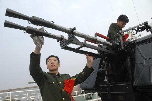 11月24日,即将退伍返乡的辽宁边防海警二支队老兵冯明超和李成宇最后一次擦拭艇上的设备。新华社发(刘海东 摄)