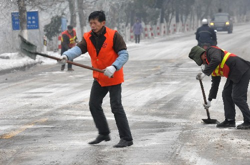 1月25日,工作人员在湖南宁乡县境内的319国道上撒盐除冰。 新华社记者 龙弘涛 摄