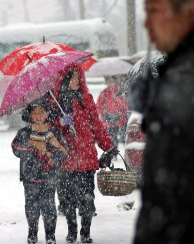 1月26日,乘客冒雪来到巢湖汽车站等车。 新华社发