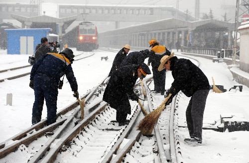 1月27日,兰州火车站工作人员紧急清扫铁轨道岔上的积雪。 新华社记者 韩传号 摄