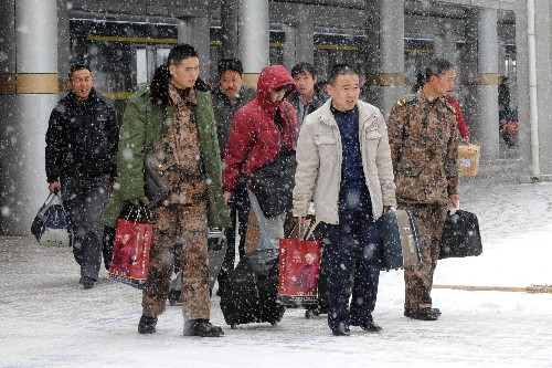 1月27日,下车旅客冒雪走在兰州火车站内。 新华社记者 韩传号 摄
