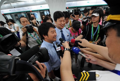7月19日,记者采访地铁奥运支线首趟列车驾驶员刘磊(左)、孙崇纬。当日上午,在京媒体记者抢先体验即将于下午正式开通的北京地铁奥运支线。北京地铁奥运支线位于北京市南北中轴线下,奥林匹克中心区内,全线共设4座车站,是惟一直接进入奥运中心区的地铁线路。 新华社记者 李文摄