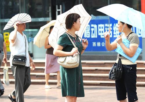 9月24日,室外活动的市民选择了各自的遮阳工具。 新华社记者 周衡义 摄