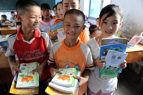 这是2008年9月1日,江西樟树市第二小学五(1)班邓文俊(中)等同学领到免费教科书。国务院决定,从2008年秋季学期开始,在全国范围内全部免除城市义务教育阶段学生学杂费。这是继农村义务教育经费保障机制改革后,又一项重要民生工程。 新华社发