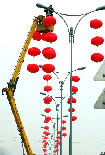   1月21日,工人给贵阳市贵溪大道董家堰路段的灯架悬挂红灯笼